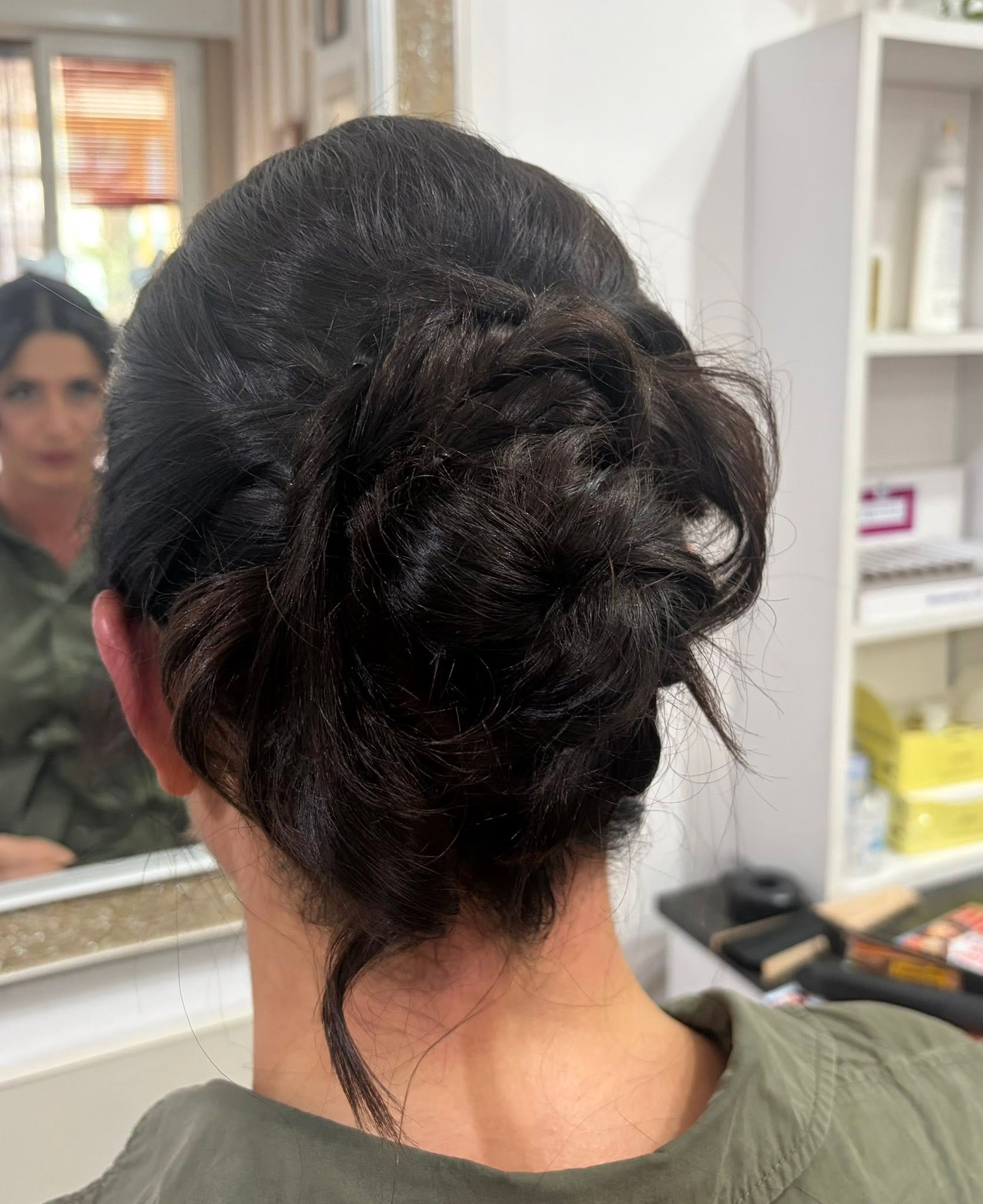 Raccolto su capelli scuri, visto da dietro nel salone GEA